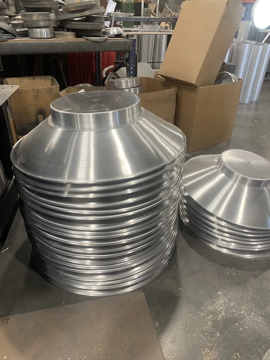 Stacks of spun aluminum shades ready for finishing